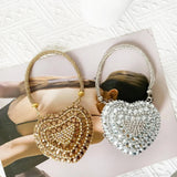 Bolso de mano en forma de corazón adornado con diamantes brillantes.