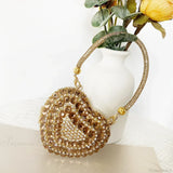 Bolso de mano en forma de corazón adornado con diamantes brillantes.