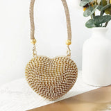 Bolso de mano en forma de corazón adornado con diamantes brillantes.