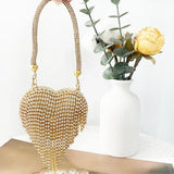 Bolso de mano en forma de corazón adornado con diamantes brillantes.