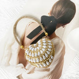 Bolso de mano en forma de corazón adornado con diamantes brillantes.
