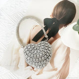 Bolso de mano en forma de corazón adornado con diamantes brillantes.