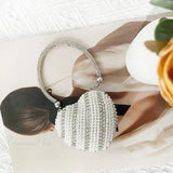 Bolso de mano en forma de corazón adornado con diamantes brillantes.