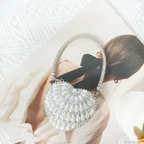 Bolso de mano en forma de corazón adornado con diamantes brillantes.