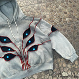 Sudadera con capucha de hip-hop con aplicación de ojo en la costura superior.