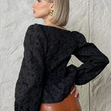 Blusa sofisticada con mangas abullonadas, cuello cuadrado y tejido jacquard.