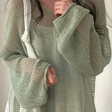Blusa elegante, holgada y de manga larga en punto calado.