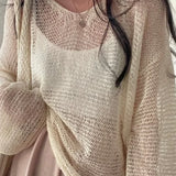 Blusa elegante, holgada y de manga larga en punto calado.