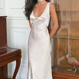 Elegante vestido largo con finos tirantes blancos y ribete de encaje.
