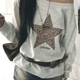 Sudadera con estampado de leopardo y estrellas, escote asimétrico y diseño de hombros descubiertos.