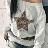 Sudadera con estampado de leopardo y estrellas, escote asimétrico y diseño de hombros descubiertos.