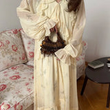 Vestido largo con cintura ajustada, escote en pico y volantes de malla.