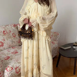 Vestido largo con cintura ajustada, escote en pico y volantes de malla.