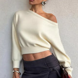 Blusa minimalista de manga larga y cuello asimétrico, corte entallado.