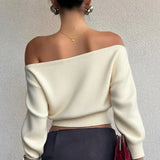Blusa minimalista de manga larga y cuello asimétrico, corte entallado.