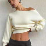 Blusa minimalista de manga larga y cuello asimétrico, corte entallado.