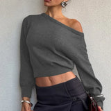 Blusa minimalista de manga larga y cuello asimétrico, corte entallado.