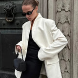 Abrigo blanco minimalista con escote en pico, elegante y casual.