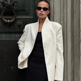 Abrigo blanco minimalista con escote en pico, elegante y casual.