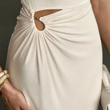 Elegante vestido largo beige con detalles de hombros descubiertos y fruncido.