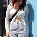Blusa asimétrica con mangas largas y lazo en la parte delantera.