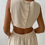 Vestido plisado de tirantes con botonadura sencilla en la parte delantera y cintura baja.