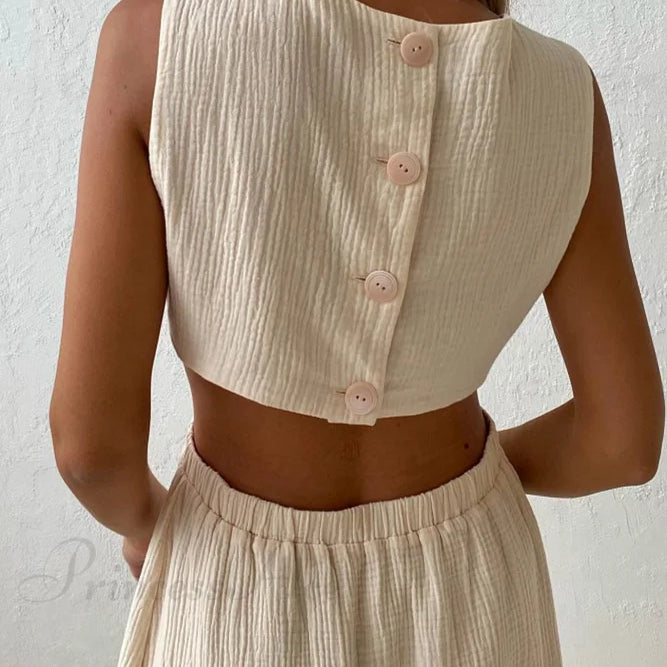 Vestido plisado de tirantes con botonadura sencilla en la parte delantera y cintura baja.