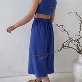 Vestido plisado de tirantes con botonadura sencilla en la parte delantera y cintura baja.