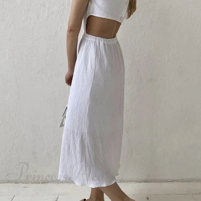 Vestido plisado de tirantes con botonadura sencilla en la parte delantera y cintura baja.