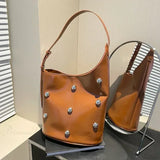 Bolso de hombro tipo cubo de PU con remaches 2025