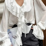 Blusa francesa con escote en V con volantes, mangas largas y cintura anudada.