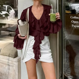 Blusa francesa con escote en V con volantes, mangas largas y cintura anudada.