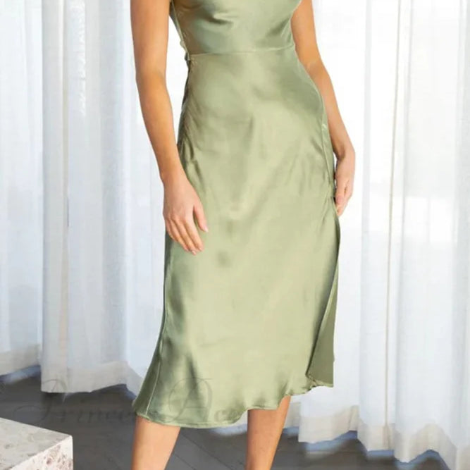 Vestido de satén con cuello vuelto y abertura torcida en la espalda.