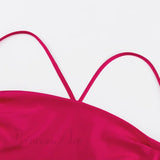 Vestido de satén con tirantes cruzados y estampado rosa, que se ata en la espalda.