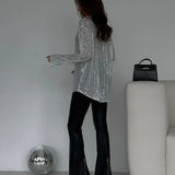 Blusa de lentejuelas con mangas largas y abertura frontal.