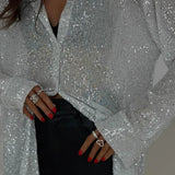 Blusa de lentejuelas con mangas largas y abertura frontal.