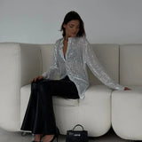 Blusa de lentejuelas con mangas largas y abertura frontal.