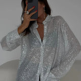 Blusa de lentejuelas con mangas largas y abertura frontal.