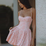 Vestido mini sexy floral con espalda abierta y tirantes finos, corte trapecio y bajo asimétrico.