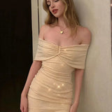 Vestido de noche corto, ajustado, con hombros descubiertos y lentejuelas.