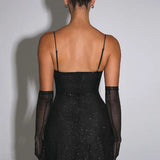 Vestido de noche brillante con finos tirantes finos y abertura.