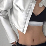 Chaqueta corta de cuero plateada con cuello alto y botones a presión.