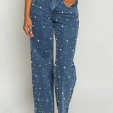 Jeans con cintura asimétrica, top cruzado, detalle de perlas y piernas rectas deshilachadas.