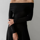 Vestido largo formal minimalista con hombros descubiertos y fluido.
