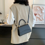 Bolso de hombro informal en piel sintética maciza con asa superior.