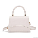 Bolso de hombro informal en piel sintética maciza con asa superior.