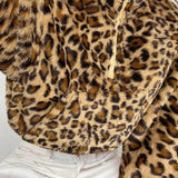 Abrigo corto y esponjoso con cuello alto y media cremallera en estampado de leopardo.