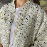 Chaqueta de lentejuelas con cuello alto y mangas largas.