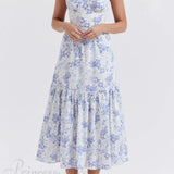 Elegante vestido midi floral con tirantes y bajo asimétrico.