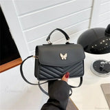 Elegante bolso de mano en piel sintética bordado con mariposas.